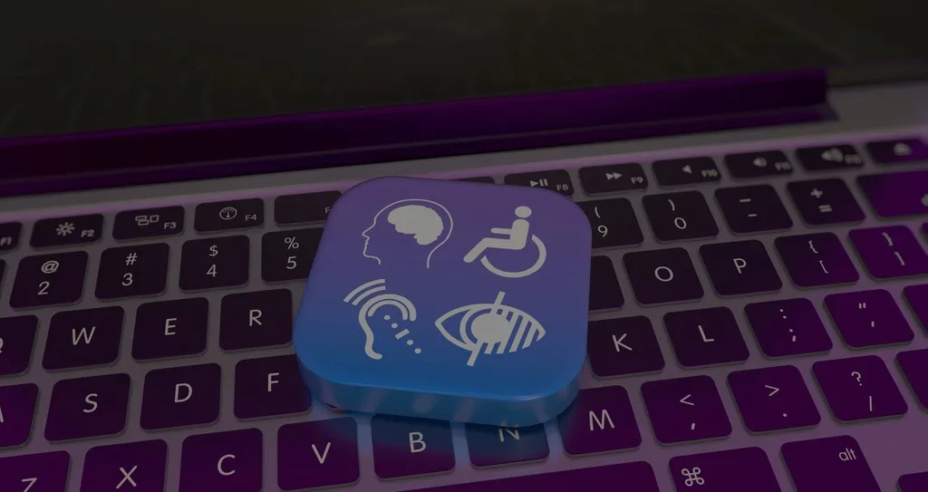 Four icons symbolizing accessibility on top of a laptop keyboard