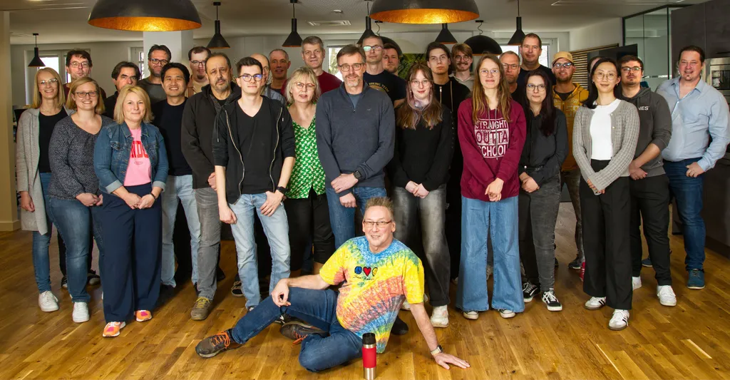 The cycos team standing (and one sitting) together in the lounge of the office